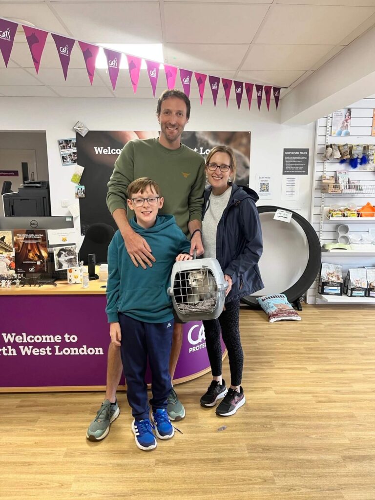 Dan and his family at a Cats Protection adoption centre holding Bluebell in a carrier.